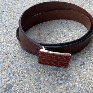 Brown leather belt by Tommy Bahama has a braided pattern belt buckle